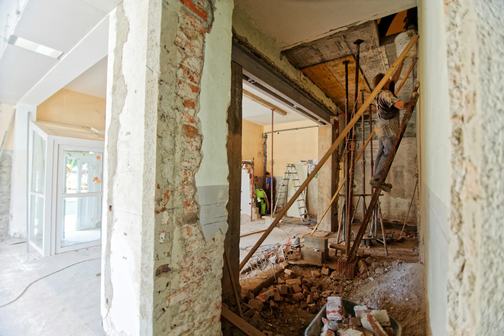 Aannemer en huiseigenaar plannen een renovatie Aannemer en huiseigenaar bekijken samen renovatieplannen